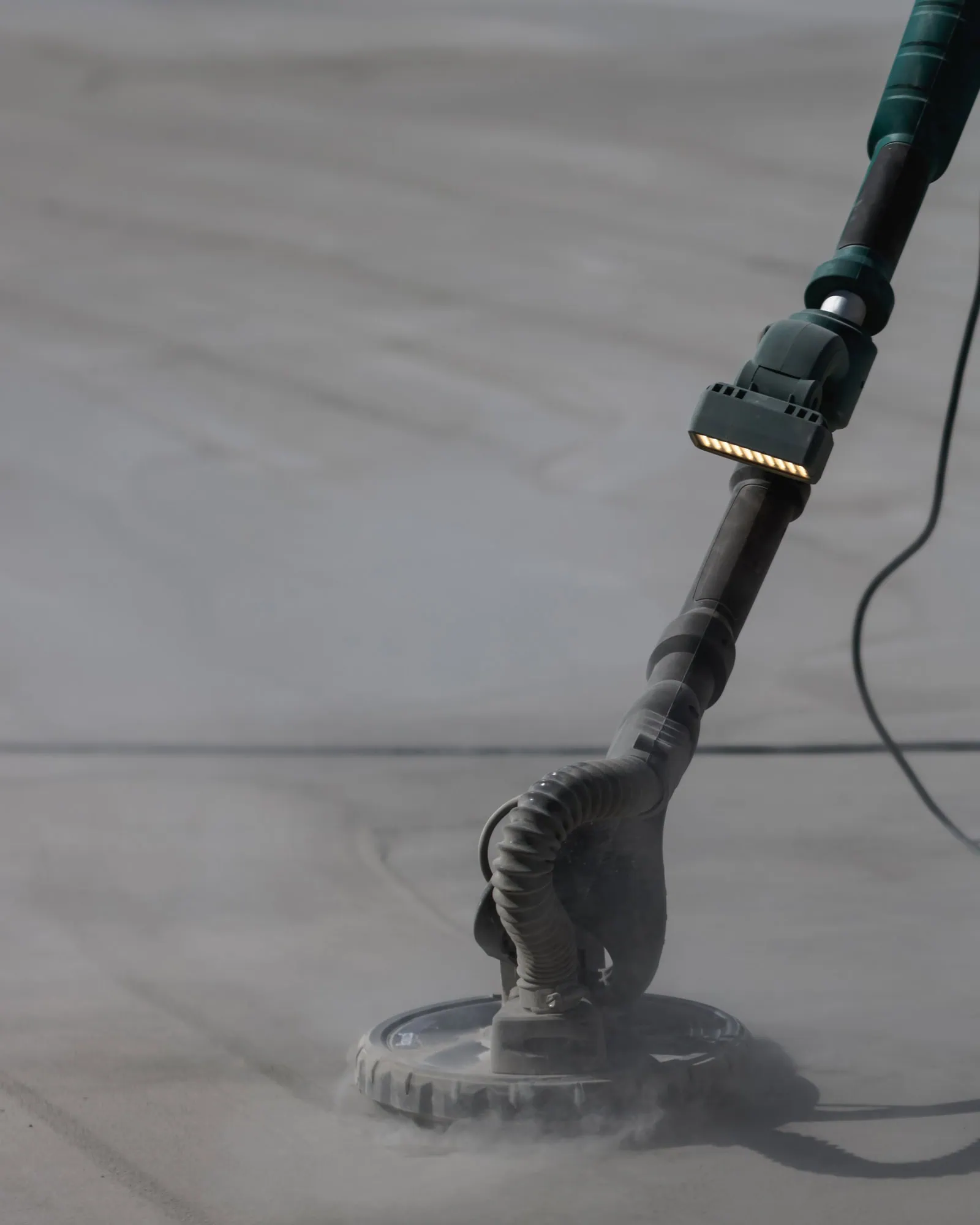 Construction worker grinding concrete surface